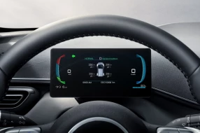 Digitales Kombiinstrument des BYD Dolphin Surf hinter dem Lenkrad mit wichtigen Fahrdaten.