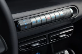 Nahaufnahme der innovativen Dreh- und Druckknöpfe im Innenraum eines Fahrzeugs mit intuitiver Steuerung.