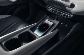 Ansicht eines drahtloses Ladefeld für Smartphones in der Mittelkonsole eines Autos mit Becherhaltern und USB-Anschlüssen.