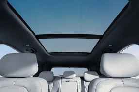 Innenraum eines BYD SEAL 6 DM-i Touring mit Blick nach oben auf das Panoramadach.