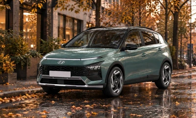 Grüner Hyundai in einer herbstlichen Stadt.
