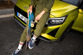 Person lehnt an Motorhaube eines Hyundai Fahrzeugs.