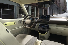 Innenraum eines Hyundai Inster mit Sicht auf das Lenkrad, Infotainment-Display und Armaturenbrett.