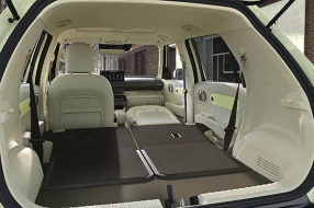 Innenraum eines Hyundai Inster mit heruntergeklappten Sitzen, durch den Kofferraum betrachtet.