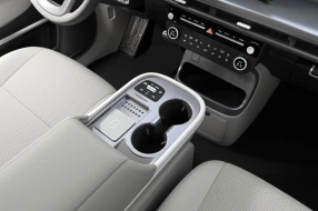 Innovative Mittelkonsole im Auto mit Ablage und Getränkehaltern sowie kabelloser Ladeschale.