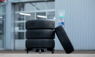 Reifensatz auf einem Rollbrett vor dem Werkstatteingang der Kummich Fahrzeugwelt.