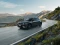 Fahrender Hyundai-SUV in einem Bergpanorama. Seitliche Frontansicht.