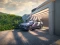 Fliederfarbener Hyundai KONA-SUV vor einer Garage am Aufladen.