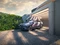 Fliederfarbener Hyundai KONA-SUV vor einer Garage am Aufladen.