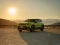 Jeep-SUV vor einem Bergpanorama, Sonnenuntergang im Hintergrund.