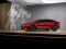 Roter Mazda in Seitenansicht vor grauer Wand.