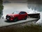 Roter Mazda SUV lässt Boot in den See auf einem Anhänger