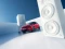 Roter Opel Corsa zwischen zwei weißen Beatboxen, seitlich-frontal.