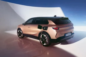 Opel Grandland Electric seitlich, Heck sichtbar, beim Laden an Ladestation.