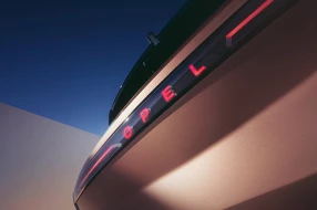 Opel Grandland Electric Heckansicht mit roten Rückleuchten und leuchtendem roten Opel-Schriftzug.