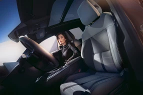 Cockpit des Opel Grandland Electric mit Blick auf Sitze, Frau sitzt auf dem Beifahrersitz.