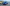 Blauer Opel Mokka auf einer Landstraße vor dem Meer.
