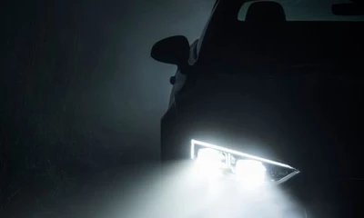 Kummich Fahrzeugwelt: Silhouette eines Autos mit aktivem Scheinwerfer bei Nebel