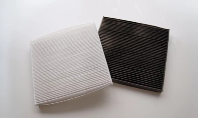 Zwei Pollenfilter im Vergleich: Vorher-Nachher-Darstellung – deutlicher Unterschied zwischen schmutzigem und sauberem Filter