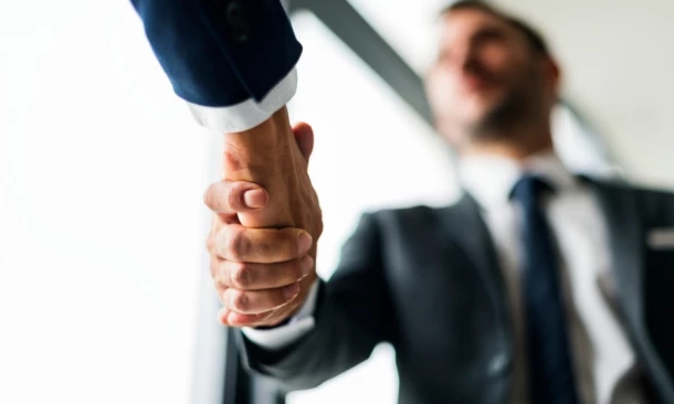 Vertrauensvoller Händedruck zwischen zwei Geschäftsleuten – Symbol für Partnerschaft und gemeinsame Ziele.
