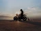 Fahrer auf einer Royal Enfield Bear 650 vor einem Sonnenuntergang.