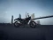 Die Royal Enfield Guerrilla 450 vor einer Skyline und Brücke, seitlich fotografiert.
