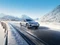 BYD Limousine fährt dynamisch durch verschneite Winterlandschaft.