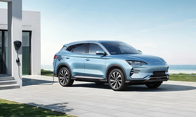 Hellblaues E-Auto in Seitenansicht lädt an der heimischen Wallbox.