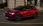 Roter Alfa Romeo auf einer Straße, seitlich.