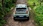 Mintgrüner Fiat Grande Panda in einem Wald, von hinten fotografiert.