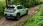Mintgrüner Fiat Grande Panda in einem Wald, seitlich von hinten fotografiert.