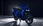Blaue Honda SH125i vor dunklem Hintergrund.