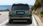 Grüner Hyundai-SUV auf der Straße vor einem Meer, von hinten aufgenommen.