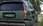 Grüner Hyundai-SUV in einem Wald am Laden, Heckansicht.