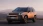 Bronzefarbener Hyundai SUV parkt vor einer Bergkulisse.