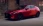 Roter Mazda vor einer industriellen Wand, frontal-seitlich.