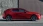 Parkender roter Mazda, auf einer Straße vor einer Wand. Seitlich.