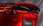 Detailaufnahme des Hecks eines roten Mazda mit Spoiler und leuchtenden LED-Rückleuchten.