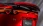 Detailaufnahme des Hecks eines roten Mazda mit Spoiler und leuchtenden LED-Rückleuchten.