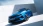 Blaues Auto in frontaler Seitenansicht vor einer Betonwand.
