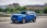 Blauer Opel Frontera auf einer städtischen Brücke.