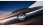 Detailaufnahme der Front eines kupferfarbenen Autos mit beleuchtetem Logo.