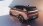 Opel Grandland Electric seitliche Heckansicht, auf weißer Fläche geparkt.