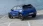 Blauer Opel Mokka vor einem Meer, von hinten fotografiert.