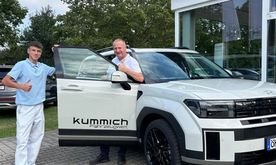 Ein junger Mann und älterer Mann posieren vor einem Hyundai Kummich Fahrzeug.