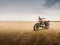 Royal Enfield Motorrad parkt in karger, offener Landschaft.