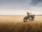 Royal Enfield Motorrad parkt in karger, offener Landschaft.