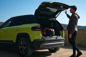 Mann öffnet die Hecktür eines Jeep Geländewagens.