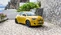 Gelber Fiat 500 vor einer mediterraner Kulisse.