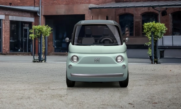 Türkisfarbener Fiat steht auf einem Vorplatz.